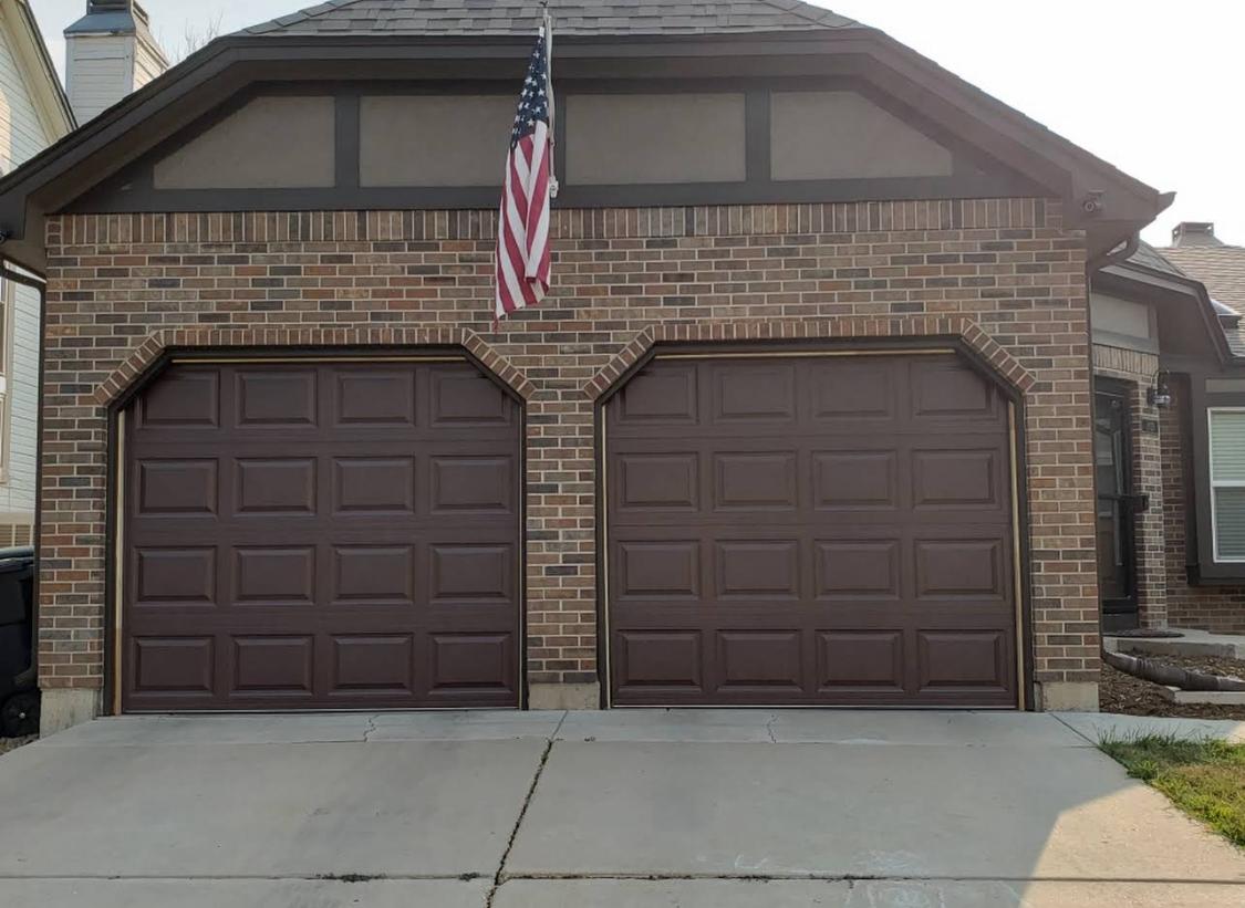 Finished two-car garage door on a brick home