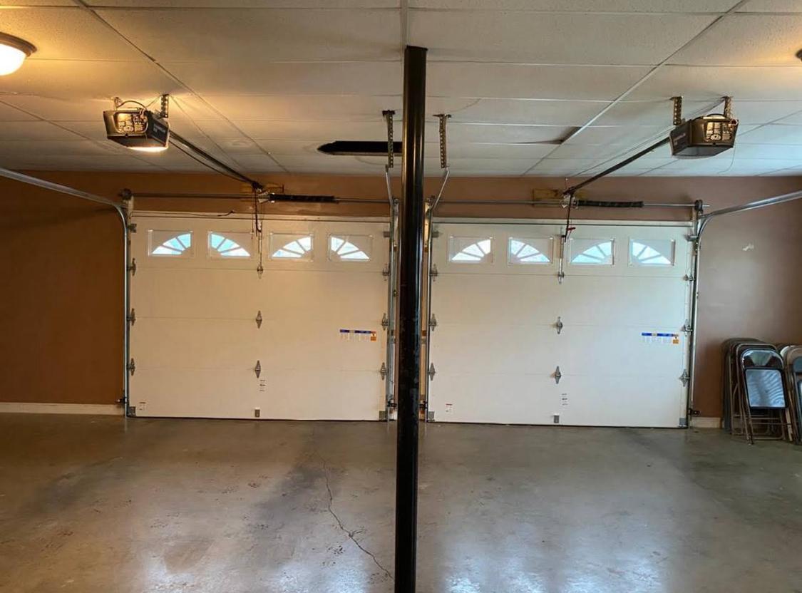 Clean two-car garage with new sectional doors, interior view
