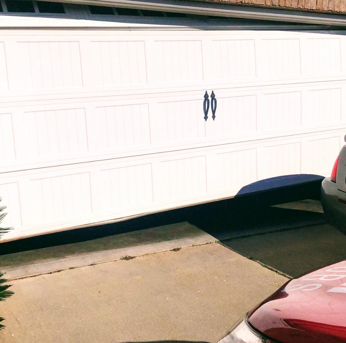 New white raised-panel garage door on a home exterior